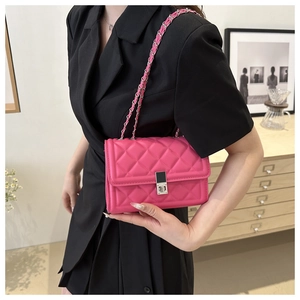 Close-up of hot pink quilted crossbody bag with silver chain strap and metal buckle