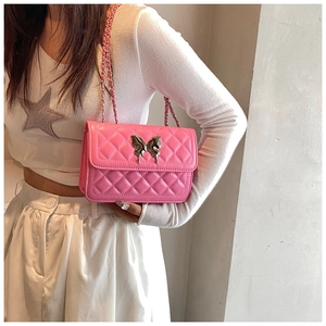 Sac bandoulière rose matelassé avec boucle papillon argentée et détail de bandoulière chaîne