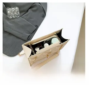 Interior view showing capacity and zipper compartment of cream quilted chain bag
