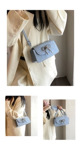 Detailed view of a light blue square bag with a sparkling bow and adjustable strap