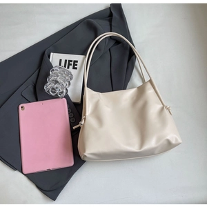 Macro view of creamy white tote bag featuring side drawstring detail and soft PU leather texture