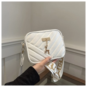 Detail of white crossbody bag with V-quilted pattern and golden deer charm pendant