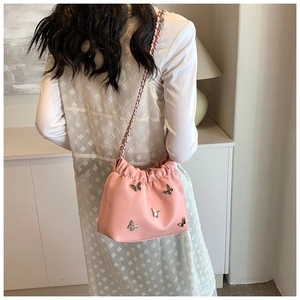 Detailsicht der rosa gefalteten Beuteltasche mit silbernen Metallschleifen und Kette
