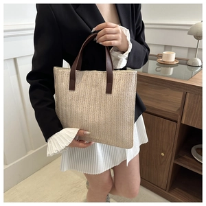 Close-up of woven tote texture with elegant brown leather handle and fine stitching