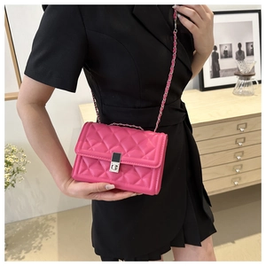 Sac à bandoulière rose fuchsia matelassé porté par un mannequin dans un salon chic