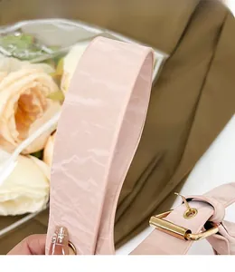 Detailed view of pink leather strap with moiré texture and golden metal buckle