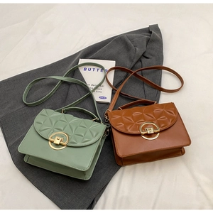 Close-up of geometric quilted texture and gold round buckle on mint and brown crossbody bags