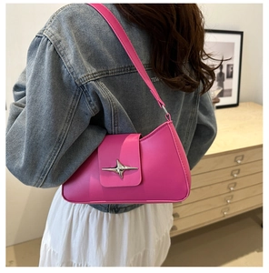 Detailed view of bright pink baguette bag with silver star buckle worn by a model
