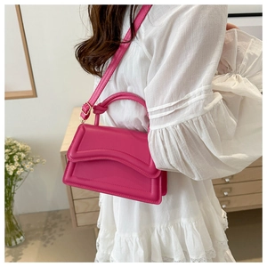 Macro detail of fuchsia leather handbag with decorative knot and streamlined stitching