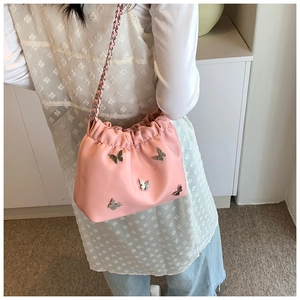 Detail der rosa Falten-Beuteltasche mit silbernen Schmetterlingen und Metallkette