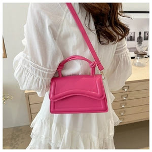 Fuchsia fashional handbag with wavy stitching and knot detail shown on a model