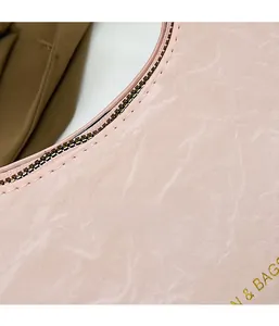 Close-up of pink crescent bag showing marbled texture and silver metal zipper detail