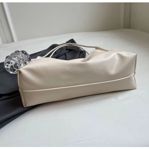 Detail view of cream shoulder bag with soft textured faux leather and spacious interior
