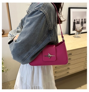 Detail of fuchsia underarm bag with silver star-shaped metallic buckle and smooth leather