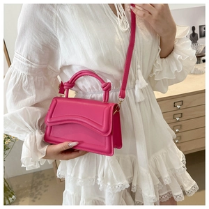 Close-up of bright pink fashion bag with wave embossed flap and knotted top handle