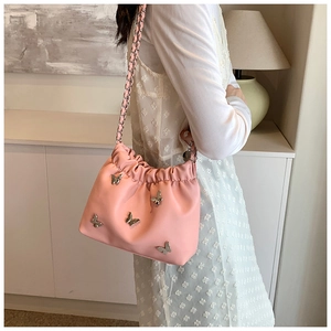 Details der rosa Plissee-Beuteltasche mit silbernen Schmetterlingen und Kette