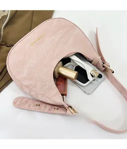 Internal capacity of pink crescent bag showing space for phone, sunglasses and lipstick