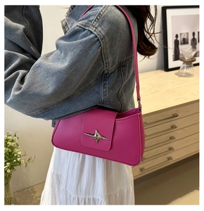 Detail of vibrant rose pink underarm bag with silver star buckle on denim jacket