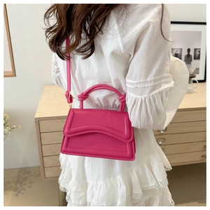 Rose pink PU leather bag featuring a unique layered flap design and knotted handle detail