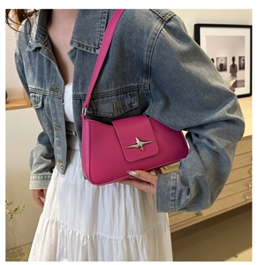 Rose pink leather underarm bag with silver star buckle worn with a denim jacket