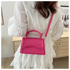 Detailed back view of a rose pink handbag with a wave-shaped flap and knotted handle detail