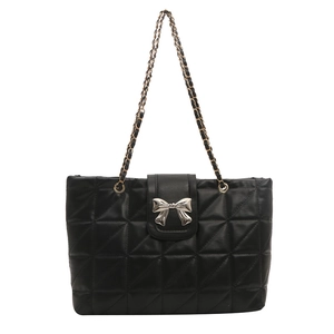 Black quilted shoulder bag with silver bow clasp and chain strap on white background
