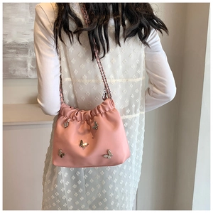 Detail der rosa Beuteltasche mit silberner Metallschmetterling-Zier und Kordelzug