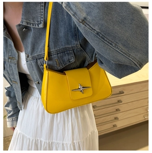 Close-up of bright yellow baguette shoulder bag featuring a silver star metal buckle