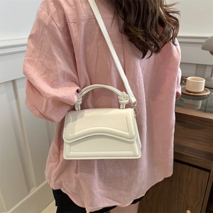 Chic cream white crossbody bag with unique knot handle and wave embossed flap detail
