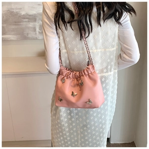 Detailansicht der rosa Beuteltasche mit silbernen Schmetterlingen und Leder-Kettengurt