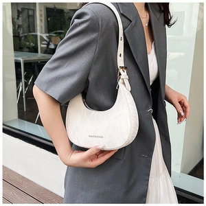 Detail of white marble textured crescent bag with gold hardware on a gray blazer outfit