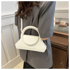 Vista dettagliata di una borsa bianca geometrica con manico tondo su modella