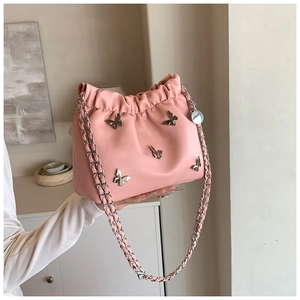 Detail der rosa Kunstleder Beuteltasche mit silbernen Metallschleifen und Kette