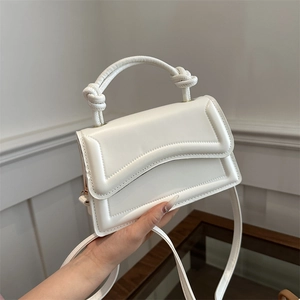 Modern white minimalist handbag with wavy flap and knot handle details for women