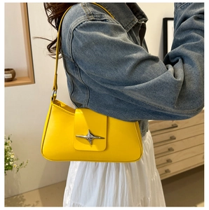 Close-up of bright yellow underarm bag with silver star buckle on denim jacket
