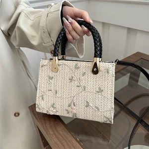 Chic woven straw handbag with floral embroidery and black leather top handles for women