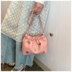 Detailaufnahme der rosa Eimertasche mit silbernen Metallschleifen und Kettenriemen