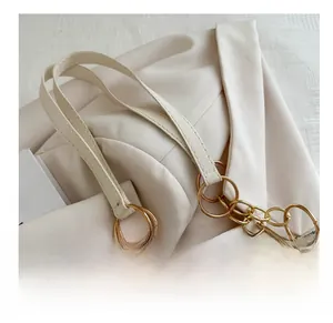 Close-up of cream leather shoulder bag with polished gold ring chain handle detail