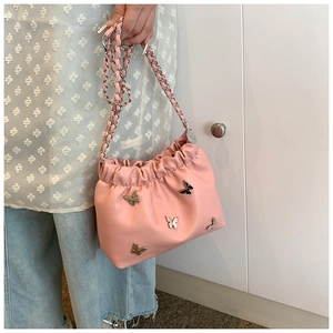 Detail der rosa Falten-Beuteltasche mit silbernen Schmetterlingsnieten und Kette