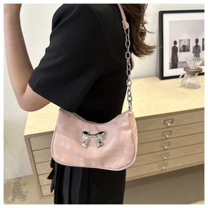 Pink satin hobo bag featuring silver bow detail and metallic chain strap worn by a model