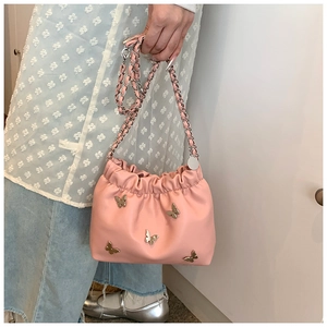 Detail der rosa Beuteltasche mit fünf silbernen Schmetterlingen und Kettenriemen