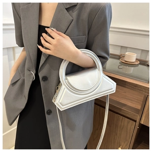 Borsa a mano geometrica argento con finitura metallica e manico su blazer grigio