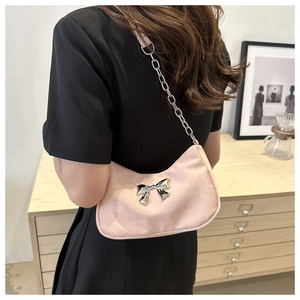 Detail of light pink hobo bag with silver metallic bow and elegant chain strap