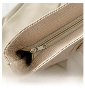 Détail de la fermeture éclair en métal et texture crocodile sur le sac fourre-tout
