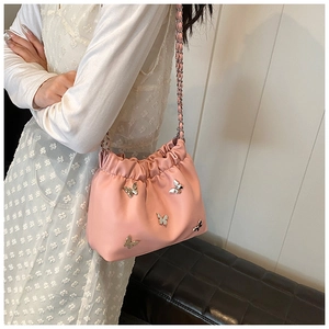 Detail der rosa Plissee-Beuteltasche mit fünf dekorativen silbernen Metallschmetterlingen