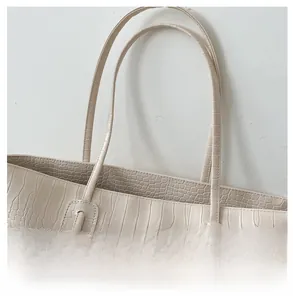 Détail d'un sac cabas élégant en relief crocodile avec fines bandoulières robustes
