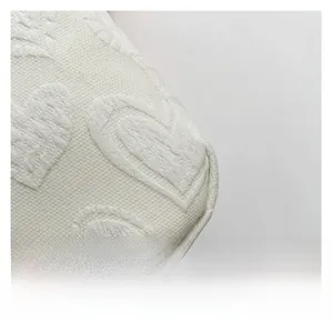 Macro view of white PU fabric featuring a 3D textured heart-shaped jacquard pattern