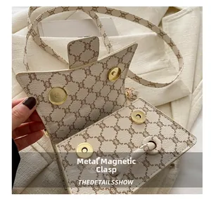 Dettaglio della chiusura magnetica dorata su una borsa a tracolla beige vintage