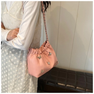Detailaufnahme einer rosa Plissee-Beuteltasche mit silbernen Metall-Schmetterlingsornamenten