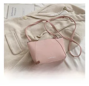 Dettaglio borsa a tracolla rosa in pelle liscia con cuciture rifinite e stile pulito